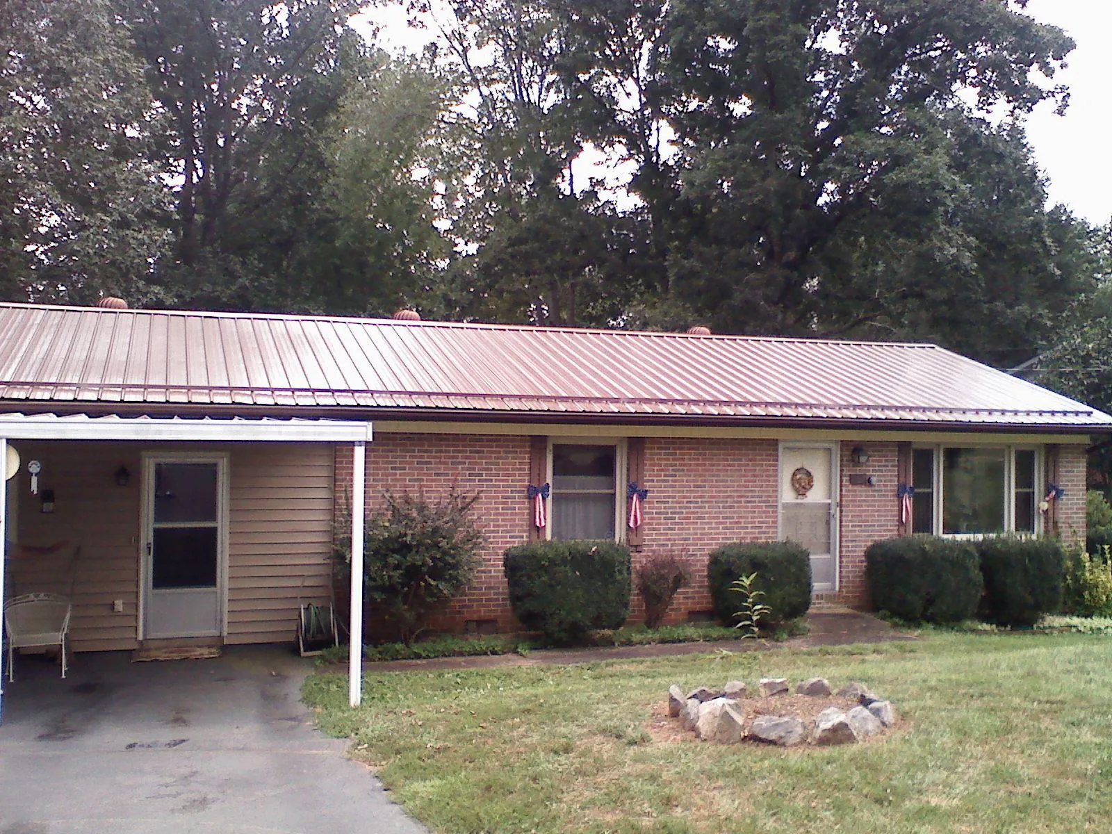 Bronze metal roof and carport on a brick ranch home — Roof Repair work by our crew in Nehalem